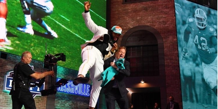 Christian Wilkins tries to cheat bump the NFL Commissioner at the NFL Draft. (Christopher Hanewinc / USAT)