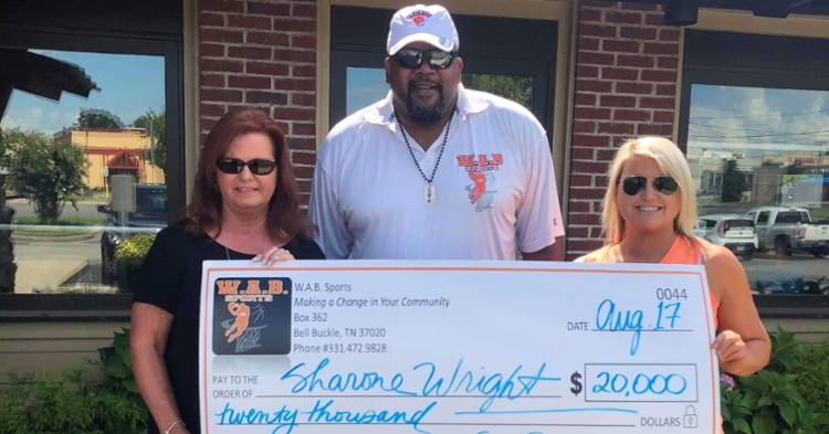 Buckingham holds the big check for Sharone Wright