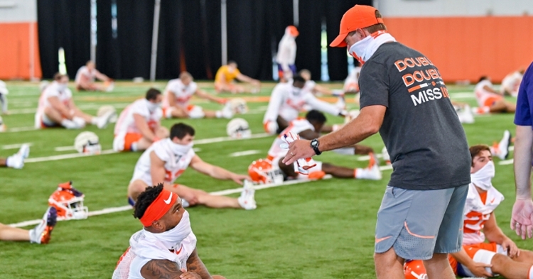 Masks Up: Swinney talks to a player during Thursday's practice (Courtesy Clemson Athletics).