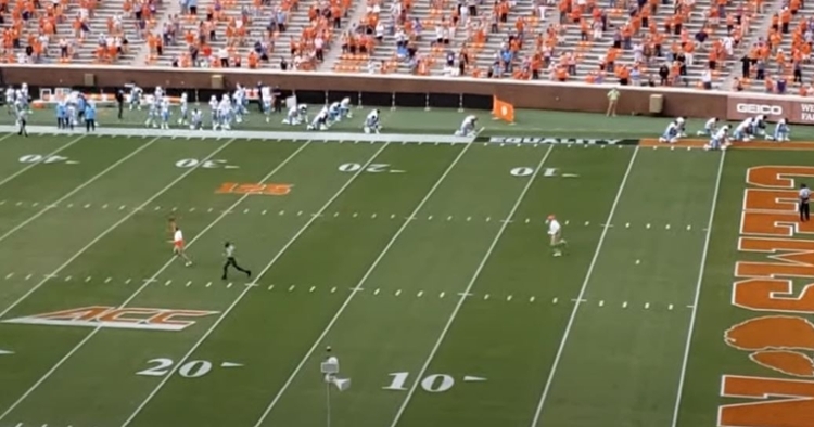 Swinney and the Highway Patrol officer race each other onto the field.