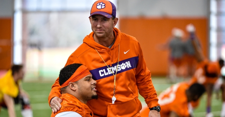 Clemson head coach Dabo Swinney hugs Xavier Thomas prior to practice.