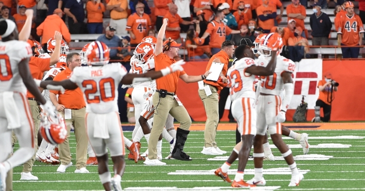 A Clemson defensive assistant joins in the celebration.